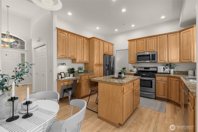 2024 N 145th St, Shoreline, WA 98133 - kitchen featuring appliances with stainless steel finishes, a center island, light wood-type flooring, light stone countertops, and recessed lighting