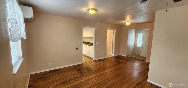 405 E Park St, Dayton, WA 99328 - empty room featuring dark wood-type flooring, a ceiling fan, baseboards, and an AC wall unit