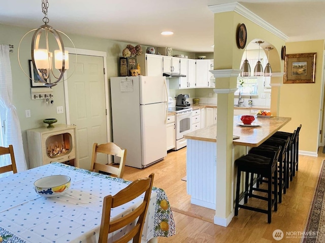 1403 Thomas St, Port Townsend, WA 98368 - kitchen with white appliances, light wood-style flooring, a chandelier, light countertops, and under cabinet range hood