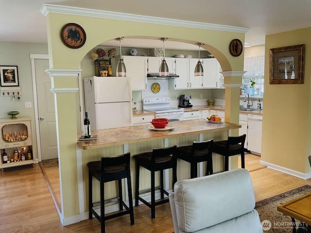 1403 Thomas St, Port Townsend, WA 98368 - kitchen featuring white appliances, a kitchen breakfast bar, white cabinets, a sink, and ornamental molding
