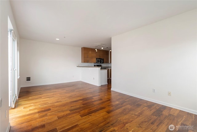 2440 Western Ave Unit 807, Seattle, WA 98121 - unfurnished living room with wood finished floors and track lighting