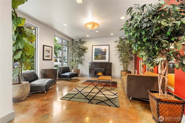2440 Western Ave Unit 807, Seattle, WA 98121 - living area with finished concrete flooring, recessed lighting, and a glass covered fireplace