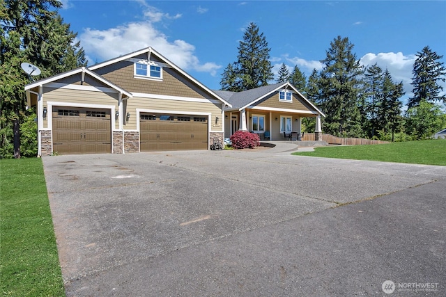 9440 Piperhill Dr SE, Olympia, WA 98513 - craftsman-style house with stone siding, an attached garage, covered porch, and concrete driveway