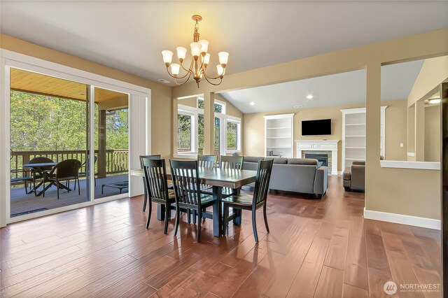 9440 Piperhill Dr SE, Olympia, WA 98513 - dining space with healthy amount of natural light, a fireplace, a chandelier, wood finished floors, and lofted ceiling