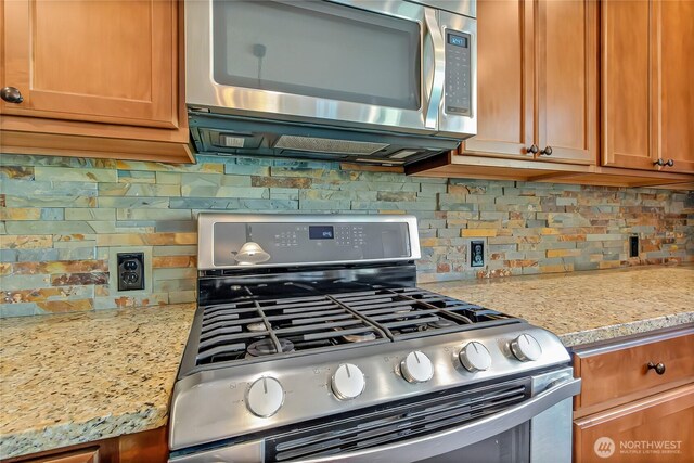 9440 Piperhill Dr SE, Olympia, WA 98513 - kitchen with stainless steel appliances, tasteful backsplash, brown cabinets, and light stone counters