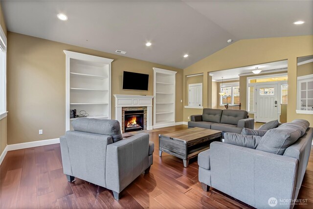 9440 Piperhill Dr SE, Olympia, WA 98513 - living area featuring dark wood finished floors, vaulted ceiling, a fireplace, baseboards, and built in shelves