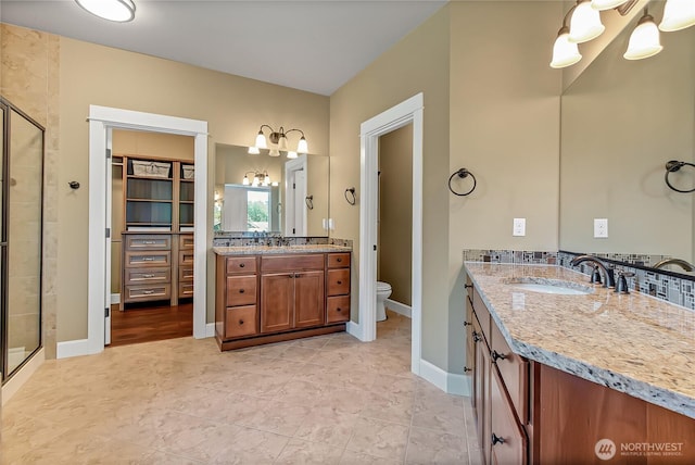 9440 Piperhill Dr SE, Olympia, WA 98513 - full bathroom with a chandelier, a stall shower, two vanities, toilet, and a walk in closet