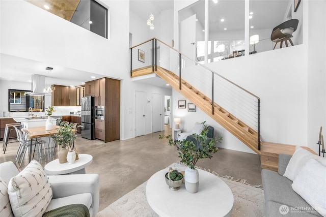 13703 Tastad Rd, Arlington, WA 98223 - living area with concrete floors, stairs, a towering ceiling, and recessed lighting