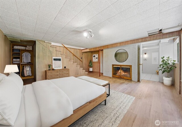 6217 Hillcrest Dr SW, Lakewood, WA 98499 - bedroom featuring wooden walls, wood finished floors, and a fireplace