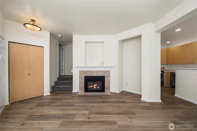 1133 63rd St SE Unit A, Auburn, WA 98092 - unfurnished living room with wood finished floors, a fireplace, recessed lighting, baseboards, and stairway