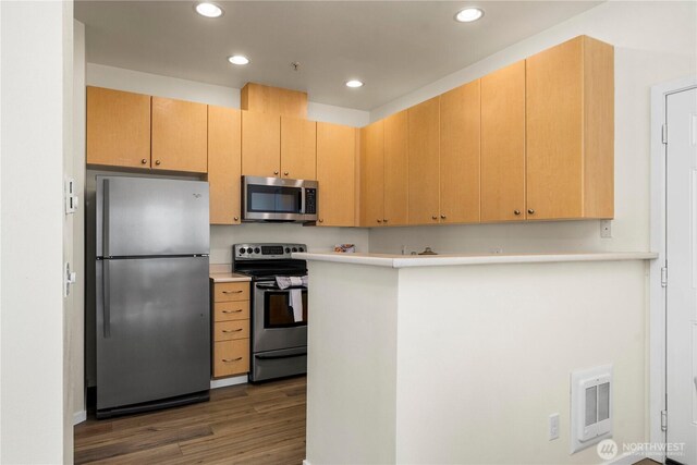 1133 63rd St SE Unit A, Auburn, WA 98092 - kitchen with appliances with stainless steel finishes, wood finished floors, light countertops, recessed lighting, and a peninsula