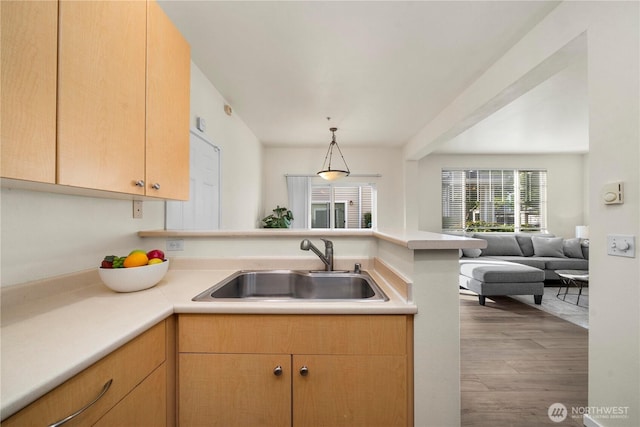 1133 63rd St SE Unit A, Auburn, WA 98092 - kitchen with a sink, a peninsula, open floor plan, wood finished floors, and light countertops