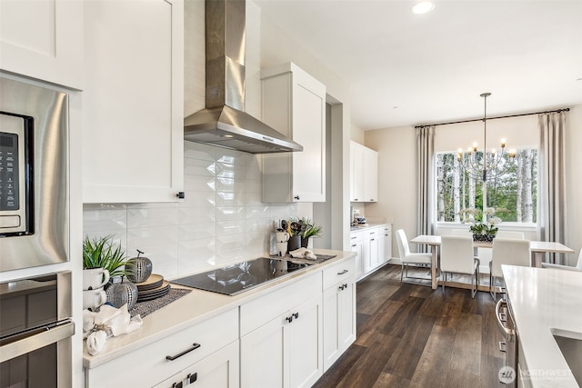 10610 134th Dr NE Unit 111, Lake Stevens, WA 98258 - kitchen featuring wall chimney range hood, appliances with stainless steel finishes, a chandelier, dark wood-style flooring, and light countertops