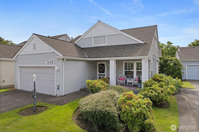 7608 145th Avenue Ct E, Sumner, WA 98390 - traditional home with a garage, covered porch, a shingled roof, driveway, and a front lawn