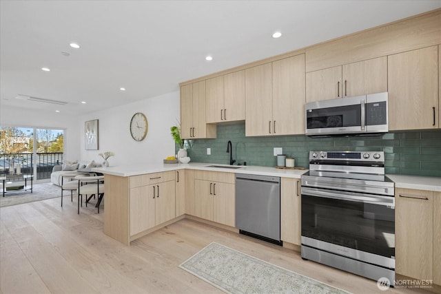6032 42nd Ave SW Unit C, Seattle, WA 98136 - kitchen featuring stainless steel appliances, light brown cabinets, a peninsula, a sink, and open floor plan