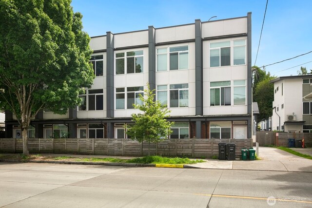 1055 S Cloverdale, Seattle, WA 98108 - view of front of house with a fenced front yard, stucco siding, and uncovered parking