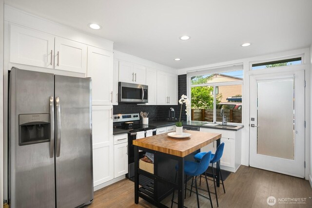 1055 S Cloverdale, Seattle, WA 98108 - kitchen featuring stainless steel appliances, a sink, white cabinetry, tasteful backsplash, and dark wood-type flooring