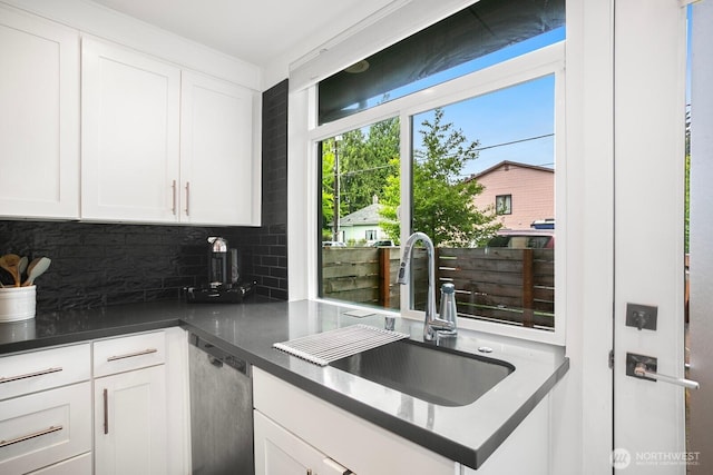 1055 S Cloverdale, Seattle, WA 98108 - kitchen with a sink, decorative backsplash, stainless steel dishwasher, and white cabinetry
