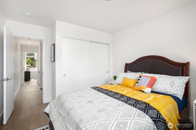 1055 S Cloverdale, Seattle, WA 98108 - bedroom featuring a closet, wood finished floors, and baseboards