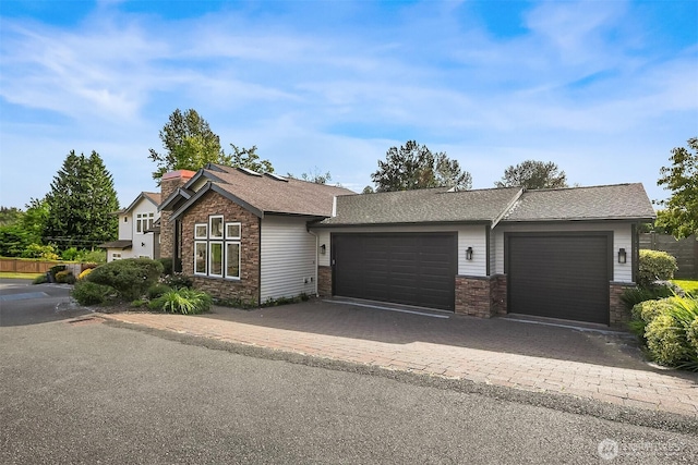 10022 NE 110th St, Kirkland, WA 98033 - view of front of home featuring a garage, decorative driveway, stone siding, and a chimney