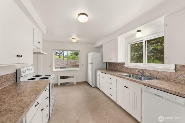 525527 16th Ave SE, Olympia, WA 98501 - kitchen with radiator heating unit, white appliances, a sink, under cabinet range hood, and tasteful backsplash