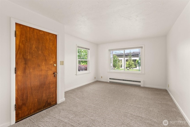525527 16th Ave SE, Olympia, WA 98501 - unfurnished room with radiator, carpet floors, baseboards, and a textured ceiling