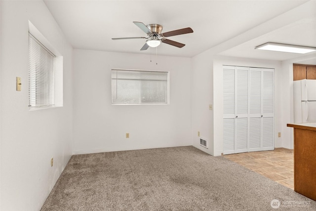 525527 16th Ave SE, Olympia, WA 98501 - unfurnished bedroom featuring freestanding refrigerator, light colored carpet, a closet, and a ceiling fan