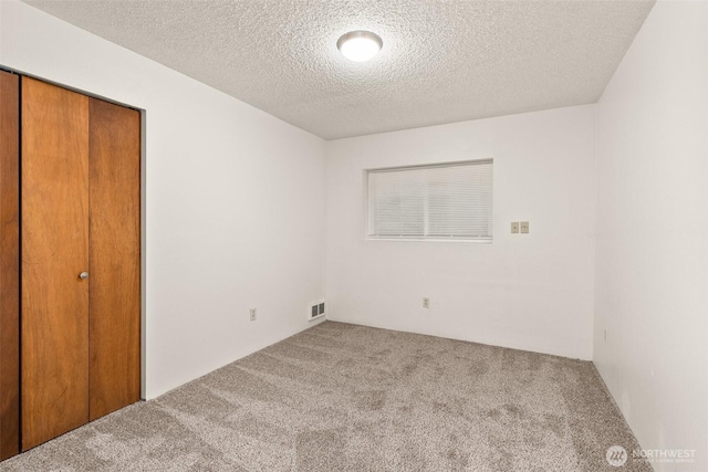 525527 16th Ave SE, Olympia, WA 98501 - unfurnished bedroom featuring carpet floors, a closet, and a textured ceiling