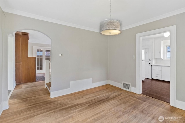 243 N Garden St, Bellingham, WA 98225 - spare room with arched walkways, ornamental molding, light wood-type flooring, baseboards, and healthy amount of natural light