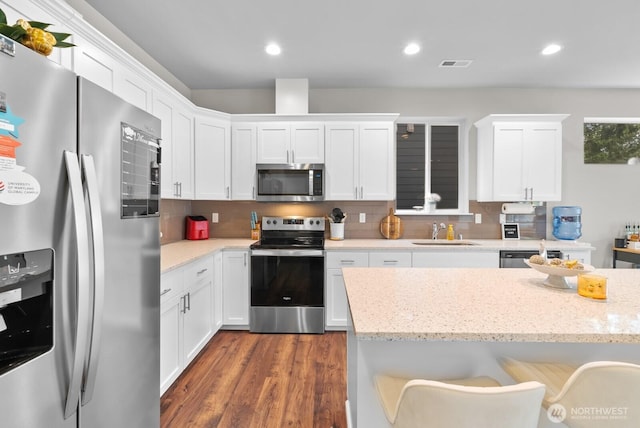 3808 181st St E, Tacoma, WA 98446 - kitchen featuring stainless steel appliances, a sink, white cabinets, dark wood-style floors, and recessed lighting