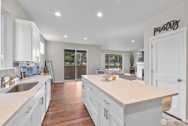 3808 181st St E, Tacoma, WA 98446 - kitchen with a sink, a kitchen island, recessed lighting, open floor plan, and white cabinets