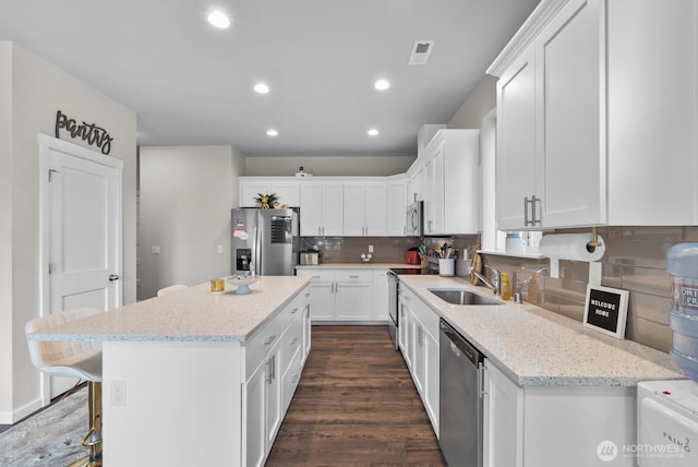 3808 181st St E, Tacoma, WA 98446 - kitchen with appliances with stainless steel finishes, a sink, a center island, dark wood finished floors, and white cabinetry