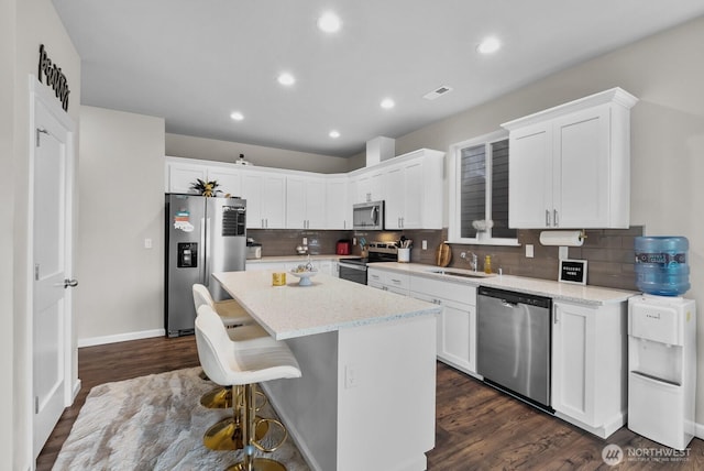 3808 181st St E, Tacoma, WA 98446 - kitchen featuring stainless steel appliances, backsplash, a center island, white cabinetry, and recessed lighting