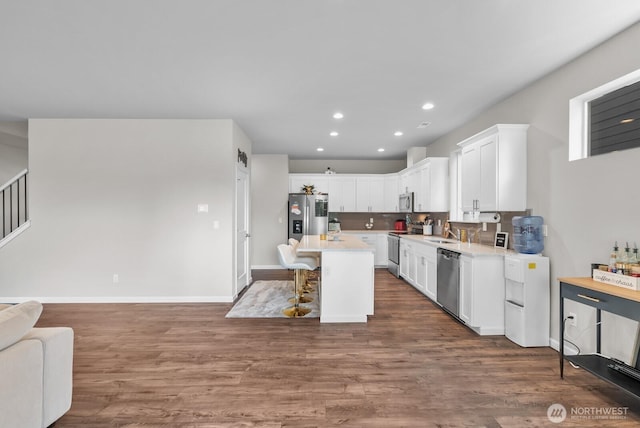 3808 181st St E, Tacoma, WA 98446 - kitchen with stainless steel appliances, a sink, light countertops, white cabinets, and a kitchen breakfast bar