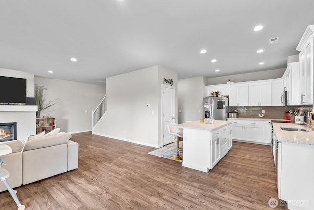 3808 181st St E, Tacoma, WA 98446 - kitchen featuring stainless steel appliances, open floor plan, a sink, a center island, and white cabinets