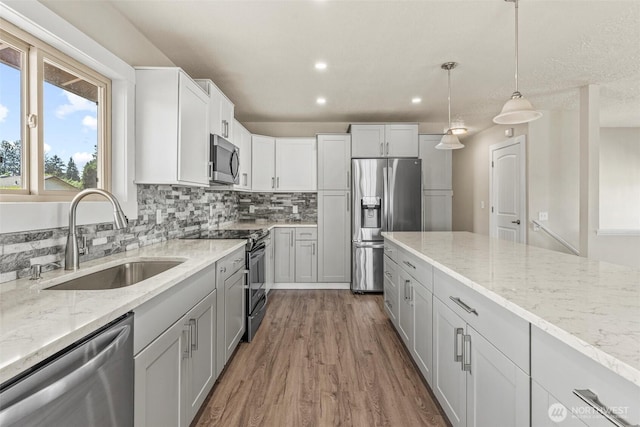 6015 NW Perthshire Rd, Vancouver, WA 98663 - kitchen with appliances with stainless steel finishes, a sink, wood finished floors, recessed lighting, and tasteful backsplash