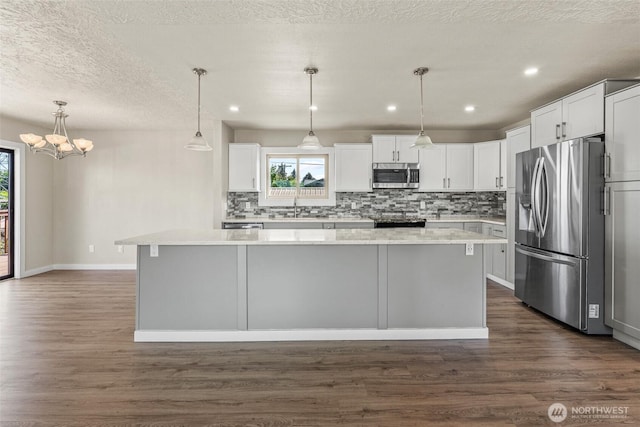 6015 NW Perthshire Rd, Vancouver, WA 98663 - kitchen featuring appliances with stainless steel finishes, tasteful backsplash, a sink, dark wood-style floors, and recessed lighting