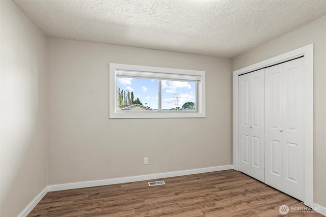 6015 NW Perthshire Rd, Vancouver, WA 98663 - unfurnished bedroom featuring wood finished floors, a closet, baseboards, and a textured ceiling