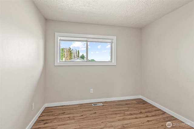 6015 NW Perthshire Rd, Vancouver, WA 98663 - unfurnished room with wood finished floors, a textured ceiling, and baseboards