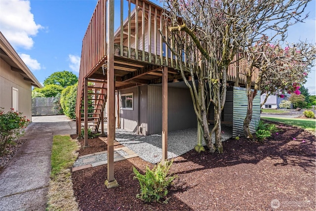 6015 NW Perthshire Rd, Vancouver, WA 98663 - view of side of home with stairway, a wooden deck, and a patio area