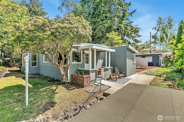 9024 29th St W, University Place, WA 98466 - view of front of home featuring board and batten siding, a front yard, and a patio