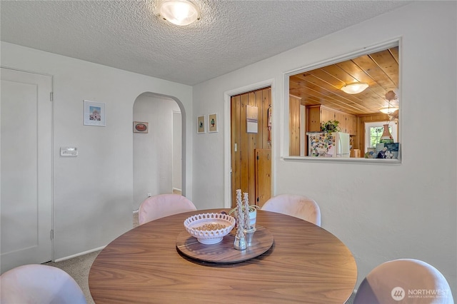 9024 29th St W, University Place, WA 98466 - carpeted dining space with arched walkways and a textured ceiling