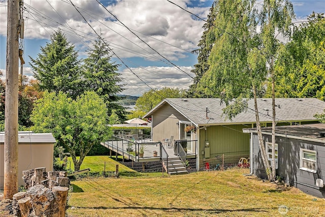9024 29th St W, University Place, WA 98466 - back of house with a lawn, a deck, roof with shingles, and an outdoor structure