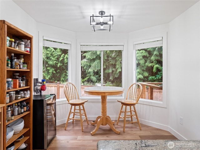 8221 122nd Ave NE, Kirkland, WA 98033 - dining area featuring beverage cooler, plenty of natural light, wood finished floors, and a chandelier