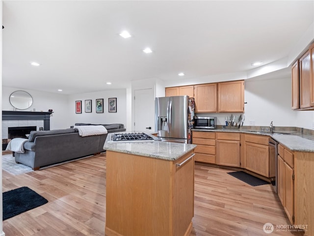 8221 122nd Ave NE, Kirkland, WA 98033 - kitchen with appliances with stainless steel finishes, a sink, light wood-type flooring, a center island, and light stone countertops