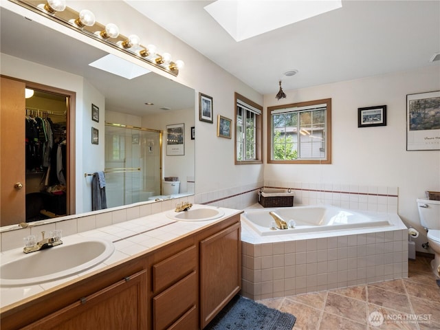 8221 122nd Ave NE, Kirkland, WA 98033 - bathroom featuring a skylight, toilet, a stall shower, double vanity, and a garden tub