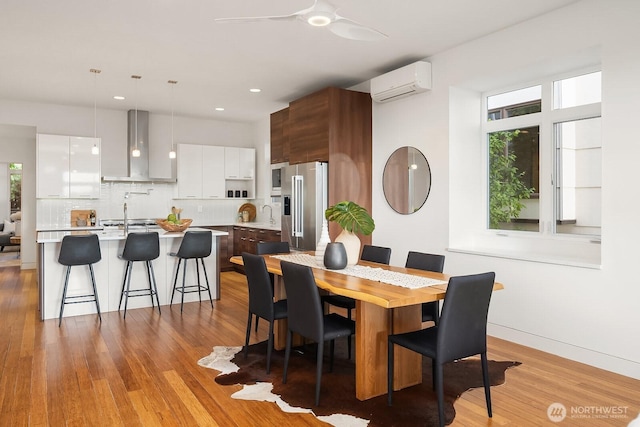 2222 Broadway E, Seattle, WA 98102 - dining room featuring a wall unit AC, light wood-type flooring, a ceiling fan, recessed lighting, and baseboards