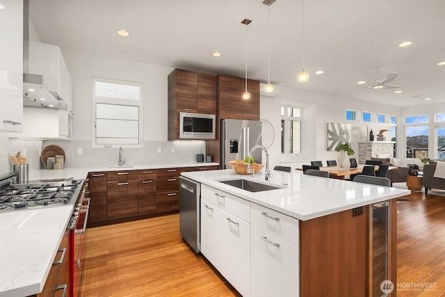 2222 Broadway E, Seattle, WA 98102 - kitchen with a sink, stainless steel appliances, a ceiling fan, backsplash, and white cabinetry