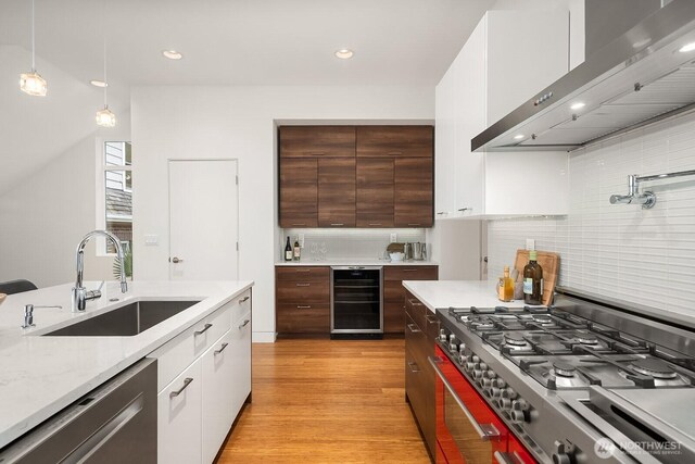 2222 Broadway E, Seattle, WA 98102 - kitchen featuring stove, wall chimney range hood, wine cooler, dishwasher, and a sink