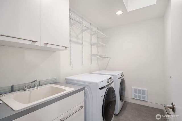 2222 Broadway E, Seattle, WA 98102 - laundry area with independent washer and dryer, cabinet space, recessed lighting, a skylight, and wood finished floors